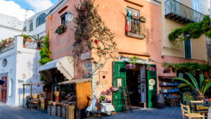 Scorcio di una via commerciale italiana con negozi di vicinato e vita urbana simbolo della resilienza del commercio di prossimità