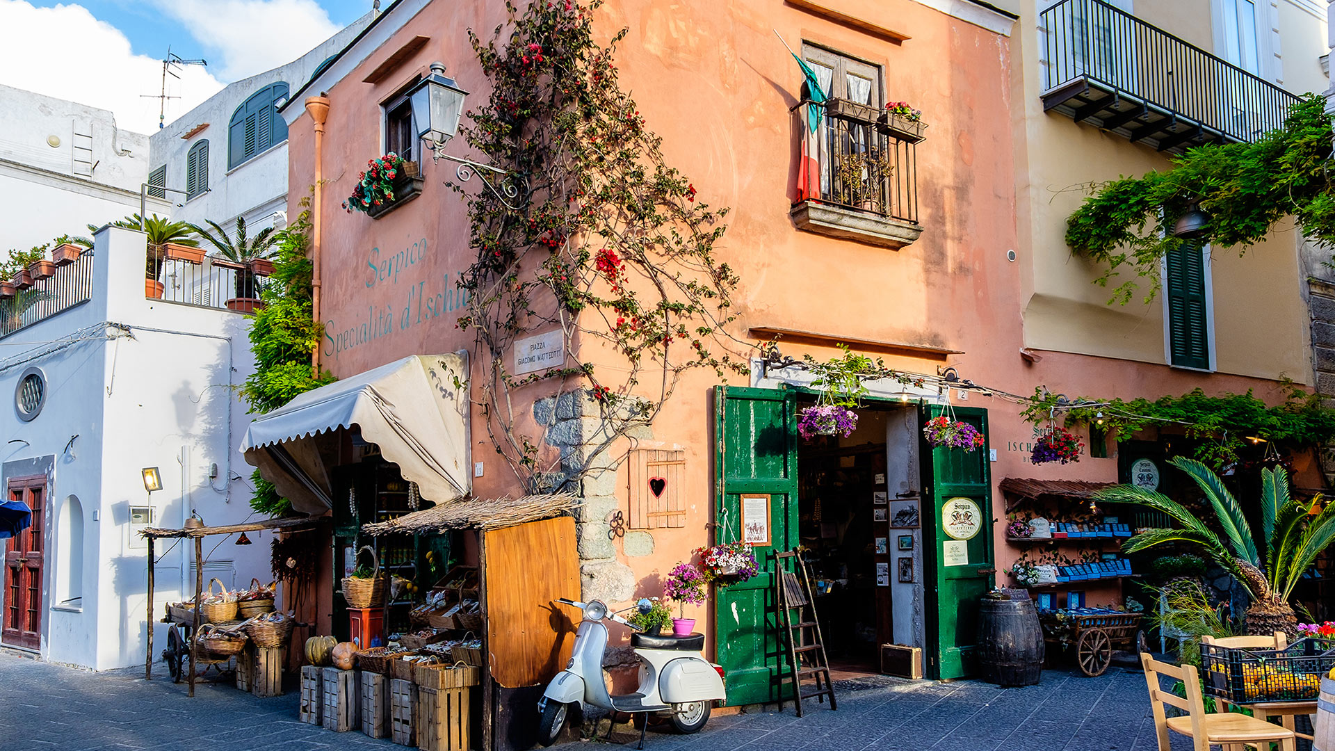 Scorcio di una via commerciale italiana con negozi di vicinato e vita urbana simbolo della resilienza del commercio di prossimità